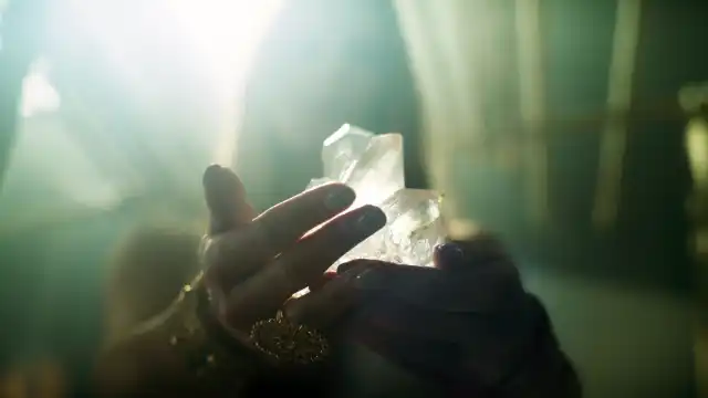 A woman holding crystals in her hand.