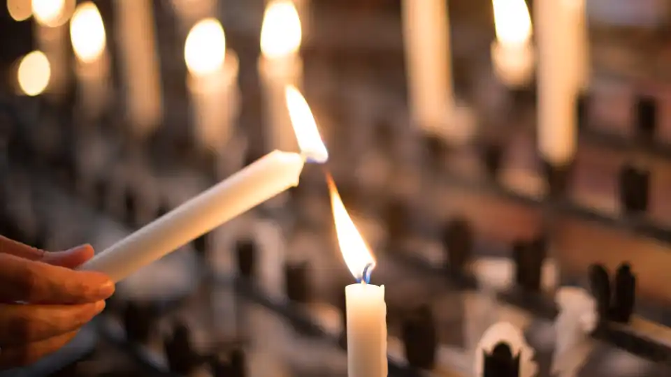 Prayer candle being lit in a church.